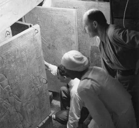 Harry Burton/Griffith Institute, Oxford University Howard Carter, his assistant Arthur Callender and an unidentified Egyptian open the doors of a gilded shrine inside Tutankhamun's tomb