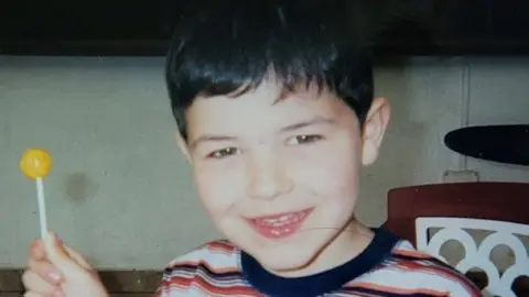 Family handout Rian Rogers as a boy holding a lollipop