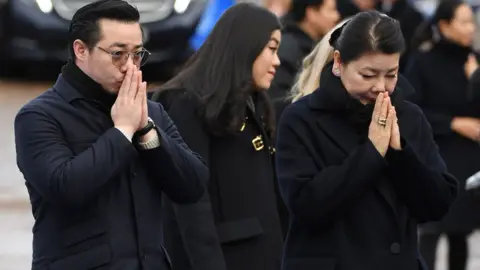 Paul ELLIS / AFP Aiyawatt Srivaddhanaprabha and Mr Vichai's widow Aimon