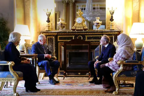 Victoria Jones / PA Media King Charles III and the Queen Consort meet with Holocaust survivor Dr Martin Stern and a survivor of the Darfur genocide, Amouna Adamlight