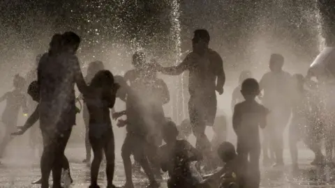 AFP/Getty Images People cool off in a fountain in Madrid.