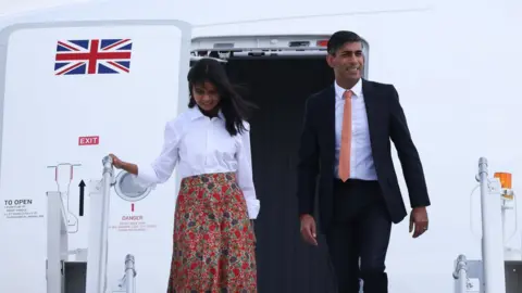 Getty Images Rishi Sunak and his wife exit his plane