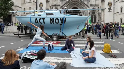 Reuters Extinction Rebellion climate activists practice yoga during a protest outside the Royal Courts of Justice in London