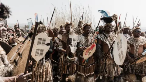 Rajesh Jantilal/AFP Men walking carrying spears and sheilds, 9 September.