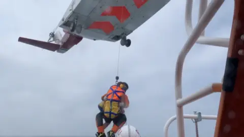 Plymouth RNLI Man being winched into aircraft