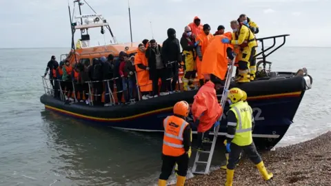 PA Media People being taken from a small boat