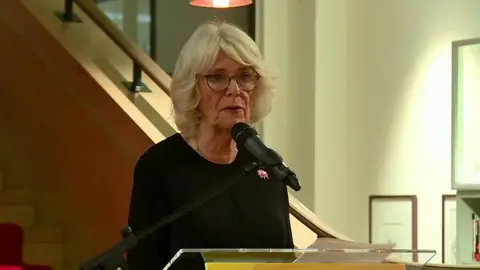 The Duchess of Cornwall speaking into a microphone on stage.