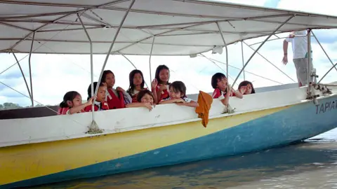 BBC Children on the solar canoe on their way to school