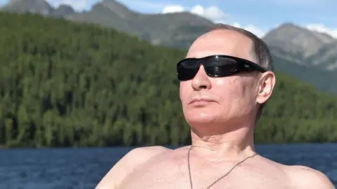 Getty Images A topless, sunglass-wearing picture of Russian President Vladimir Putin on holiday in Siberia in August