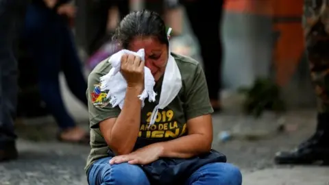 Reuters A relative reacts as police investigators collect evidence at a crime scene where a private security guard was purported killed by gang members, as the government undertakes steadily stricter measures to prevent the spread of the coronavirus disease (COVID-19), in San Martin, El Salvador April 26, 2020