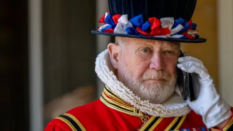 Getty Images A Yeoman of the Guard speaks on a mobile phone