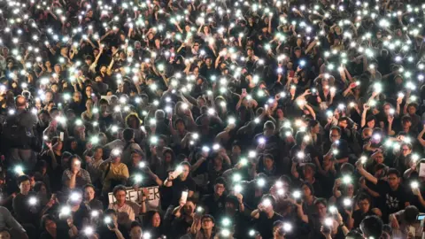 Getty Images Demonstrators hold up lights from their phones during a rally organised by Hong Kong mothers in support of extradition law protesters, in Hong Kong on July 5, 2019