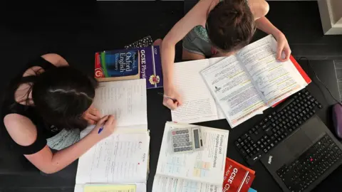 Peter Byrne/PA Wire Two young people study at home