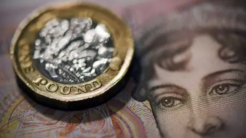 BBC Pound coin sitting on a £50 note