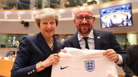 Getty Images Belgian Prime Minister and theresa May with an England shirt