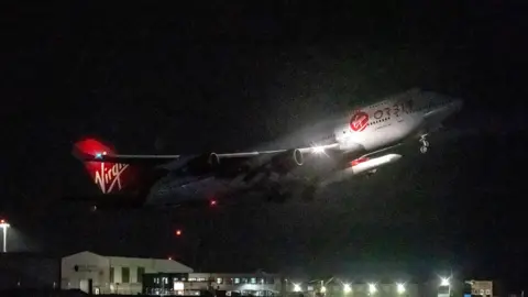 Cosmic Girl plane taking off in the dark