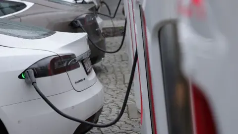 Getty Images Tesla electric cars charge at a Tesla charging station