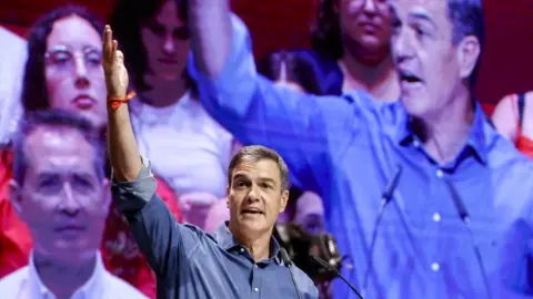 EPA Spain's Prime Minister Pedro Sanchez stands on stage in front of a screen showing his face at a meeting of his party, PSOE, in the city of Valencia, Spain, 15 July 2023.