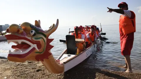 AFP Contestants take part in Uganda"s second annual Entebbe Dragon Boat Race Festival on Lake Victoria on June 16, 2018, at the lakeside city of Entebbe. The Dragon Boat festival has it"s origins in China since 2,000 years ago and commemorates a patriotic poet, Qu Yuan. The Entebbe Drangon Boat Race festival is hoping to attract tourists from China, allowing the country to reach its target of four million tourists per year