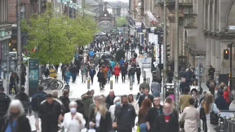 Getty Images Pedestrians walk in shopping precinct in Glasgow