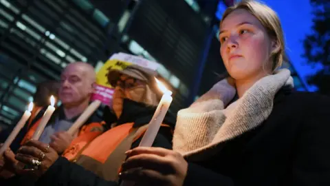 EPA People hold candles at a vigil