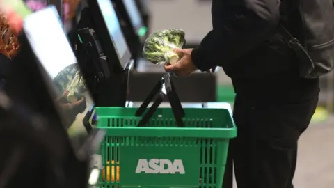 Getty Images Shopper using a self-checkout at an Asda Express convenience store