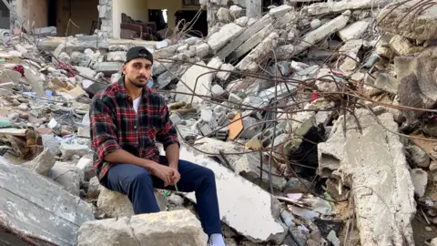 Amr Tabash Ibrahim Abuimeir by his home in Rafah Gaza, destroyed by bombing on October 30
