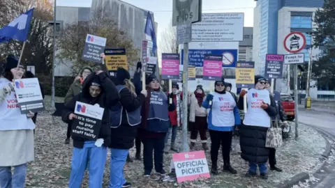 PA Media Members of the RCN on the picket line outside the University Hospital Wales in Cardiff