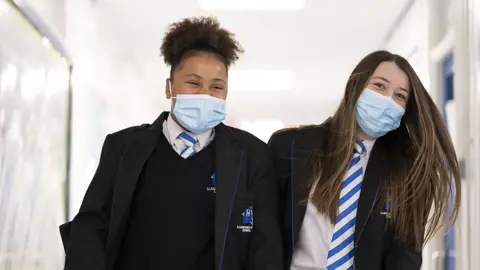 Getty Images Children wearing face masks walk down a corridor at Llanishen High School, Cardiff, on September 20, 2021