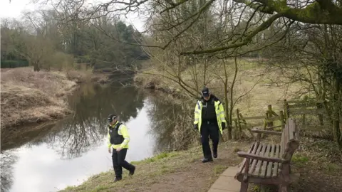 PA Media Police officers walking by the River Wyre near where Nicola Bulley's mobile phone was found