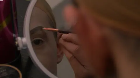 Darryl applying make up