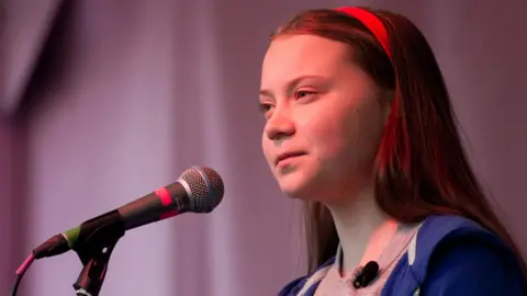 Getty Images Greta Thunberg speaking in to a microphone at a rally.