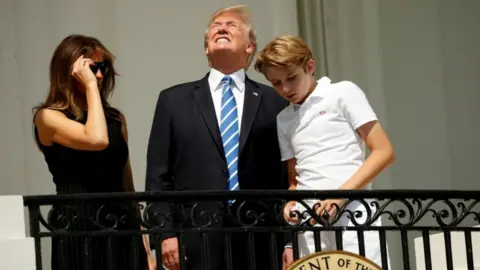 Getty Images Trump looks at the eclipse