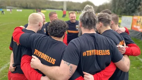 Mark Leach/BBC Rugby players from Old Redcliffians huddle together at the swabbing day for Ellis Joseph