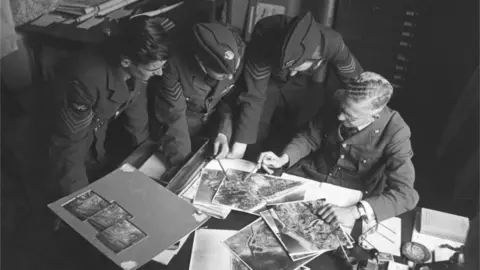 Getty Images September 1941: Airmen studying reconnaissance photos during WW II. Original Publication: Picture Post - 872 - Photo Reconnaissance - unpub. (Photo by Bert Hardy/Picture Post/Hulton Archive/Getty Images)