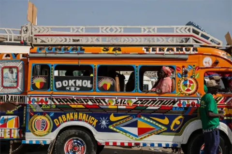 ZOHRA BENSEMRA/REUTERS A woman sits in a brightly painted bus.