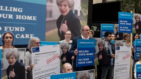 Getty Images People gather to protest Theresa May's care "floor" proposals