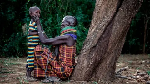 Getty Images Woman removes dirt from her son's face on Friday 4 October 2019