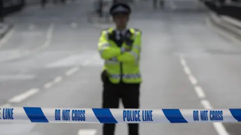 Getty Images Met Police officer behind a Do Not Cross line