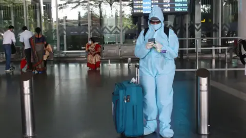 Getty Images A Passenger with protective gear arrive Netaji Subhash Chandra Bose International Airport in Kolkata on September 03,2020.