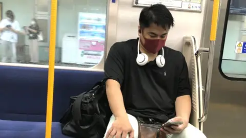 Christine Ro A neck fan being worn on the Tokyo Metro