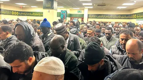 A load of men praying in a mosque