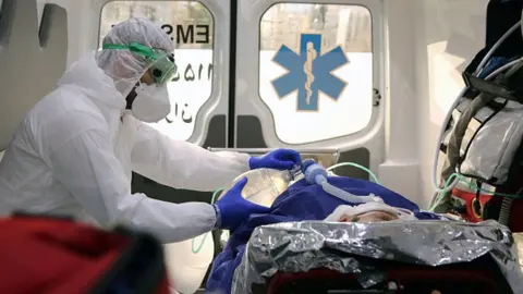 Getty Images Ambulance staff arriving with a patient at a hospital in Iran