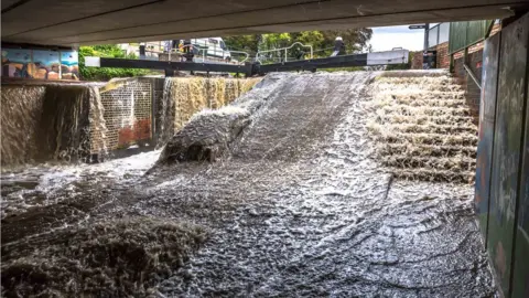 Mike Barby Canal overflowing from a lock onto a walkway in Dudbridge near Stroud