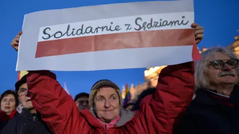 A protester holds a sign reading solidarity with judges