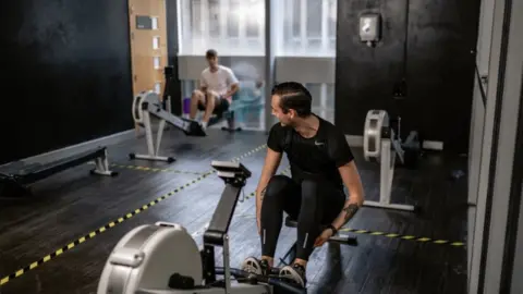 GLL Two men using gym equipment