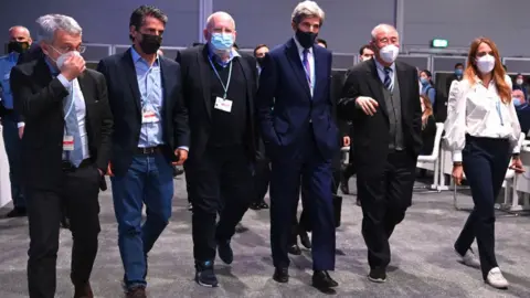 Getty Images US Special Presidential Envoy for Climate John Kerry (4th L) and Chief Negotiator of China, Xie Zhenhua (5th L) leave the room at the UN Climate Change Conference COP26 on November 13, 2021 in Glasgow, Scotland.