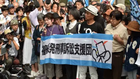 Getty Images Activists outside a court in Tokyo following the trial of three Tepco executives over the Fukushima disaster 2019