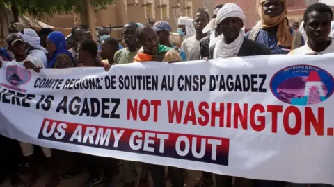 EPA Demonstrators hold a banner during a protest rally to demand the withdrawal of US troops from Niger, in Agadez, 21 April 2024.