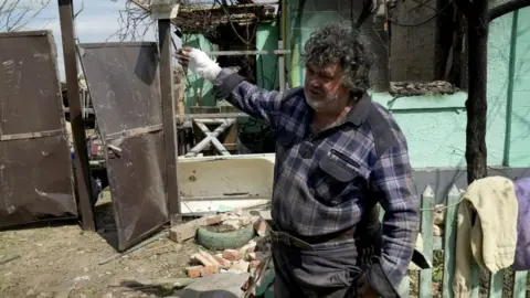 Serhii, a resident of Vovchansk shows his destroyed home